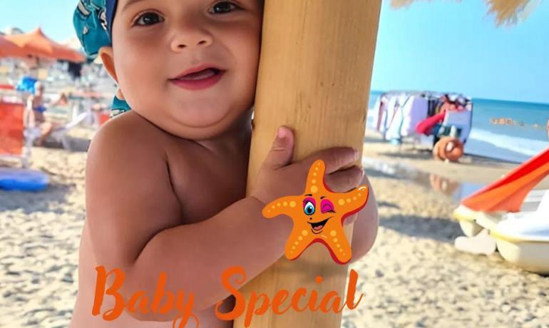 Bambino sorridente in spiaggia con cappello blu.