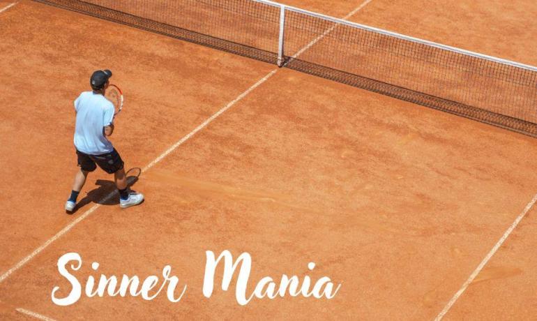 Giocatori di tennis su campo in terra battuta, scritta 'Sinner Mania'.