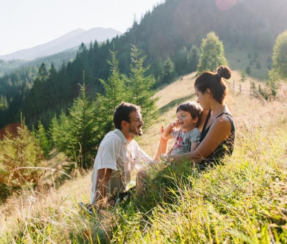 Famiglia felice in montagna, godendo il sole e la natura.