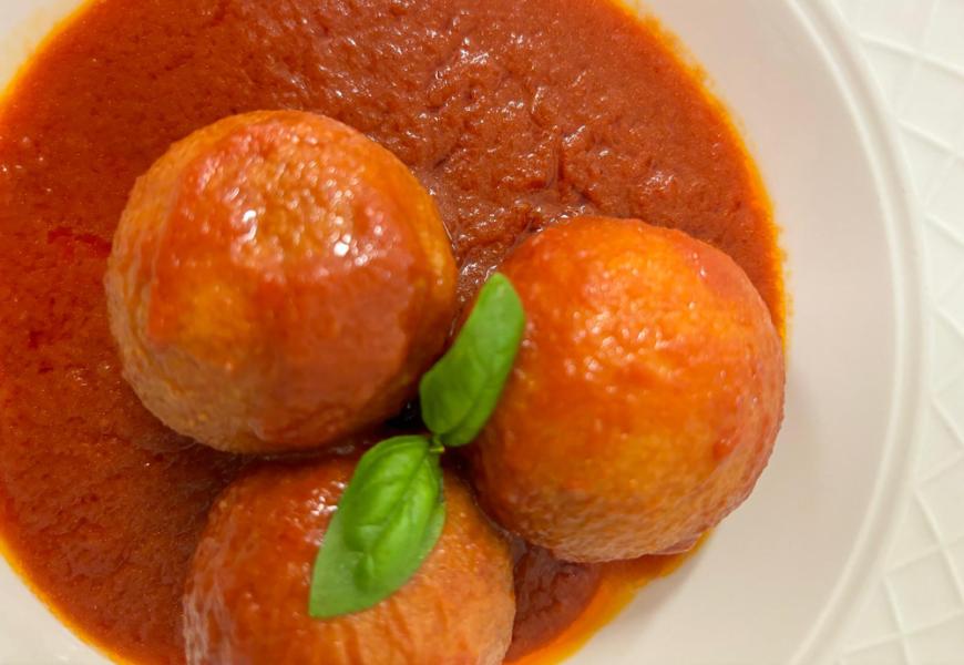 Polpette al sugo con foglie di basilico.