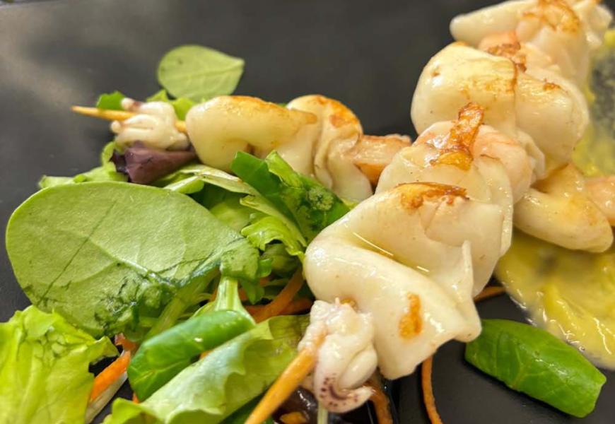 Spiedini di calamari con insalata e crema.