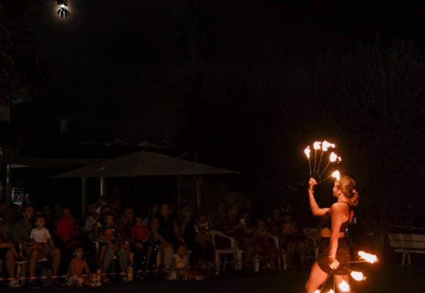 Artista di fuoco performa davanti a un pubblico di notte.